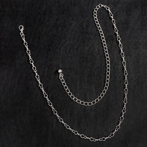 Catena chic in metallo argento con maglie a cuore traforate e chiusura su fondo pietra