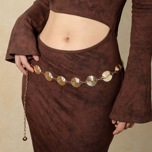 Detail of elegant gold metal waist chain with spiral texture on circular links and adjustable clasp