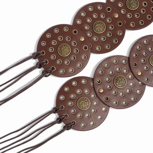 Detail of western style leather belt with round metal discs and bohemian pattern