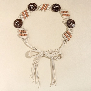Détail de ceinture tressée boho avec boutons en noix de coco et perles ethniques