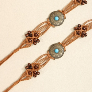 Macro detail of Bohemian waist belt with turquoise stone and hand-woven wooden beads