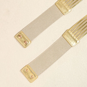 Détail de ceintures élastiques dorées champagne avec boucles en métal et bouts miroir