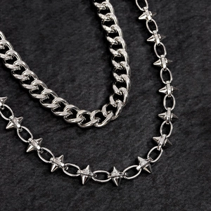 Dettaglio della catena cubana punk argento e collana con borchie a punta