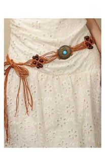 Close-up of a bohemian woven waist belt featuring vintage bronze buckle and turquoise bead
