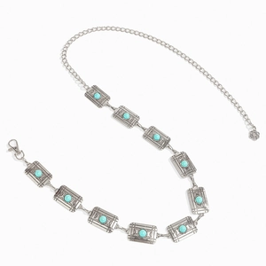 Detail of vintage silver metal chain belt with turquoise stones and floral charm pendant