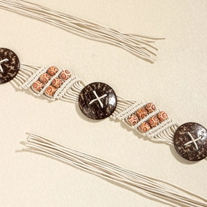 Détail de la ceinture tressée en coton avec perles en bois et boucles en noix de coco