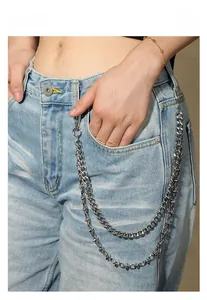 Dettaglio della catena punk argento a doppio strato con punte a stella su jeans blu