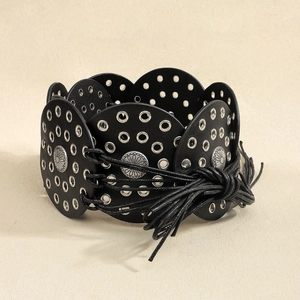 Detailed view of bohemian wide belt with silver eyelets and retro sun pattern metal buckles