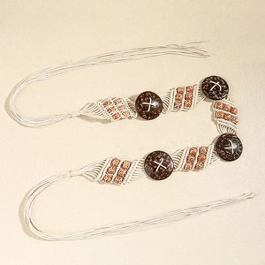 Détail de la ceinture bohème en corde tressée avec perles en bois et breloques en noix de coco
