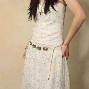 Detailed view of bohemian vintage gold waist chain with turquoise on lace dress