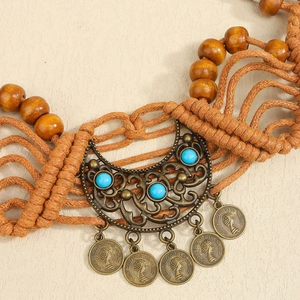 Bohemian braided belt with bronze moon pendant and vintage coins on white background