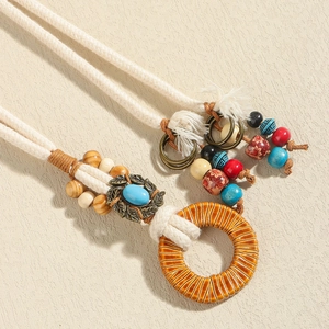 Macro detail of Bohemian hand-woven waist chain with wooden beads and leaf pendant