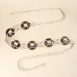 Détail de la ceinture tressée bohème avec disques en bois marron et longs glands