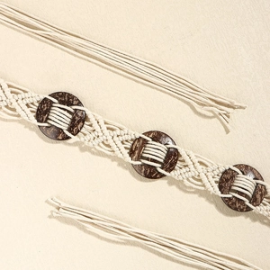 Détail d'une ceinture bohème en coton tressé avec anneaux en bois marron et glands