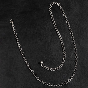 Dettaglio della catena a maglie argentate a forma di cuore con chiusura a moschettone regolabile
