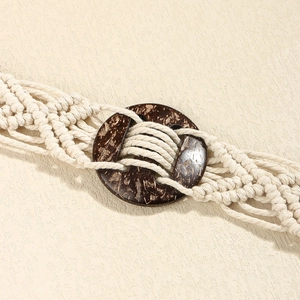 Gros plan sur une ceinture en coton tissé bohème avec boucle circulaire marron