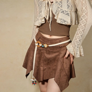 Detail of bohemian hand-woven belt with colorful beads on a brown suede mini skirt