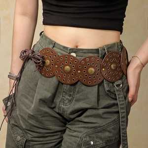 Detail eines Western-Ledergürtels mit runden Metallplatten und Sonnenblumenmuster