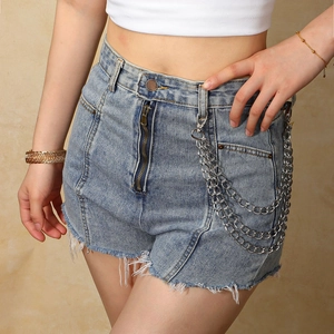 Macro view of high-waist denim shorts with frayed edges and triple-layer metal chains