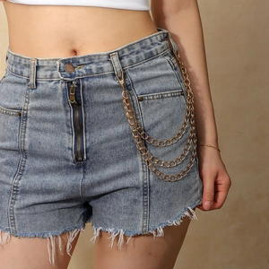 Detailed close-up of a three-layer gold metal punk waist chain on denim shorts