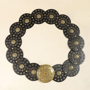 Macro view of vintage bohemian waist belt with gold floral buckle and metal eyelets