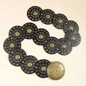 Bohemian vintage belt featuring black leather discs and ornate gold engraved buckle