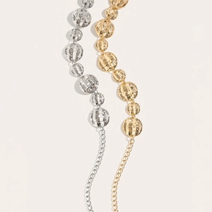 Detailed close-up of gold and silver metallic waist chains with textured sphere links