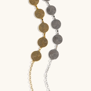 Détail de chaînes de taille bohèmes dorées et argentées avec disques à texture spirale