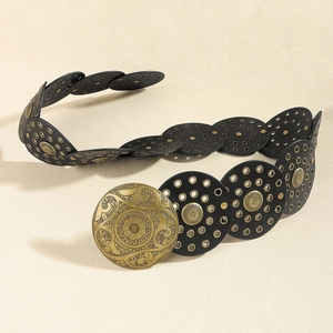 Detailed macro view of bohemian waist belt featuring black discs and gold rivet studs