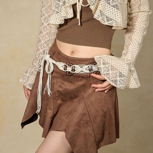 Détail de la ceinture tressée bohème sur une jupe en daim marron avec des accents de dentelle