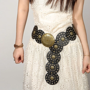 Detail of bohemian black leather waist belt with antique bronze studs on lace dress