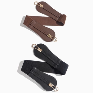 Detail of coffee and black elastic waist belts with gold metal buckles on white background