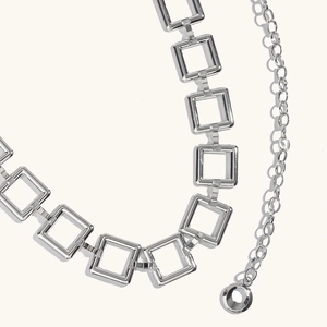 Detailed close-up of shiny silver square link waist chain with minimalist geometric design