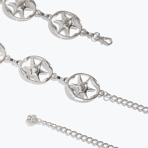 Détails d'une chaîne de taille en métal argenté avec maillons étoile de mer et pendentif rose