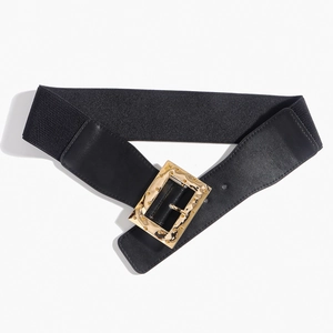 Détail d'une ceinture élastique noire avec boucle métallique rectangulaire dorée