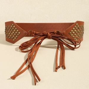 Close-up of vintage brown corset belt with metallic rivets and long fringe tassels