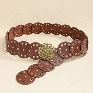 Nahaufnahme des Vintage-Gürtels mit geprägter Bronzeschnalle und Nietendetails