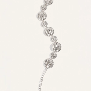Macro detail of French style metallic waist chain with hollow spherical beads and link chain