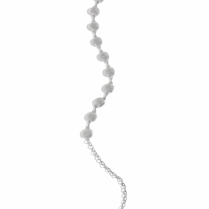Detailed macro view of textured silver metal beads on a minimalist fashion waist chain belt