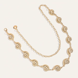 Close-up of golden nautilus shell waist chain with textured metallic link pendants