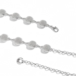Detail view of silver metal waist chain featuring textured spherical beads and lobster clasp