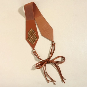 Vintage brown elastic corset belt with metallic rivets and long tassel bow detail