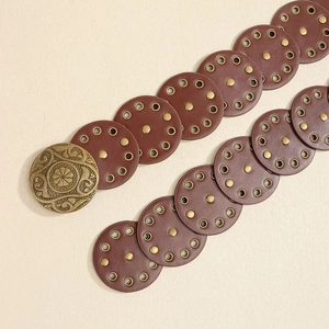 Detail eines Vintage-Western-Gürtels mit geprägter Blumenschnalle und Nieten-Leder