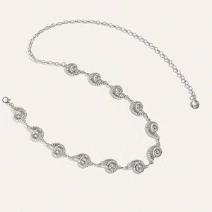 Detailed view of silver metal waist chain featuring conch shell charms and lobster clasp