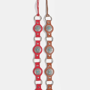 Detail of bohemian leather belts with turquoise inlays and sunburst metal plates