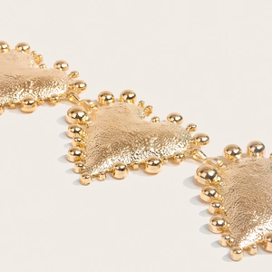 Detailed close-up of golden heart chain with hammer texture and metallic sphere edges