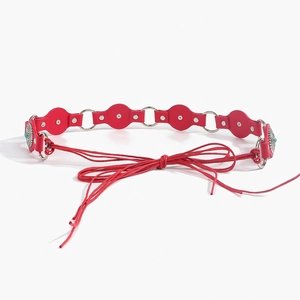 Detailed macro view of red leather panels with turquoise beads and silver metal rings