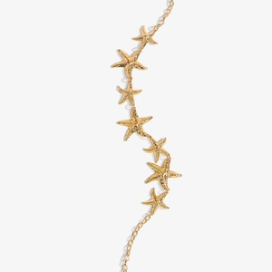 Detail of golden starfish waist chain with textured hammer finish for beach dresses