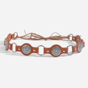 Detail of bohemian leather belt featuring turquoise inlays and silver metal ring links