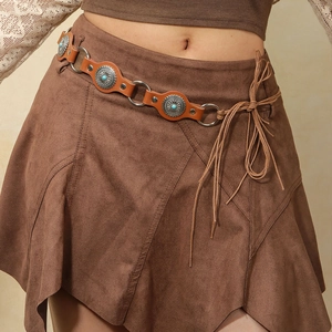 Detail of bohemian belt with turquoise metal studs on a brown suede skirt with fringes